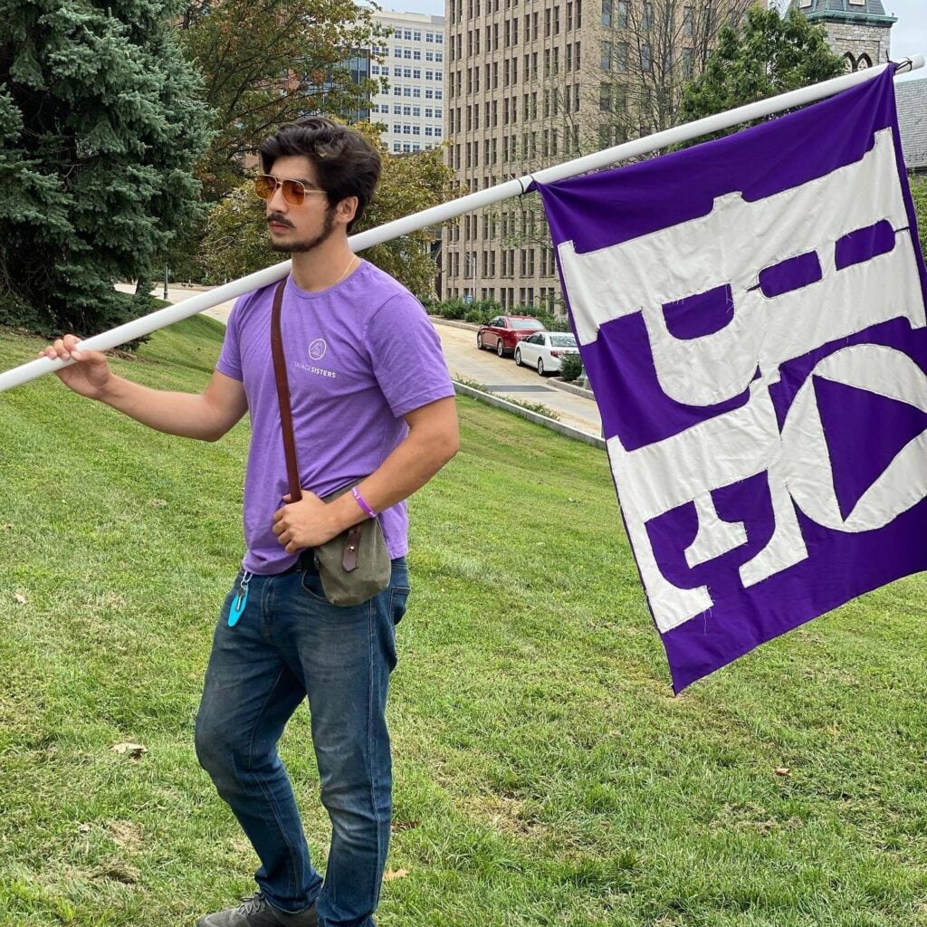 Adam Al-Asad holding a sign that says "Hope"