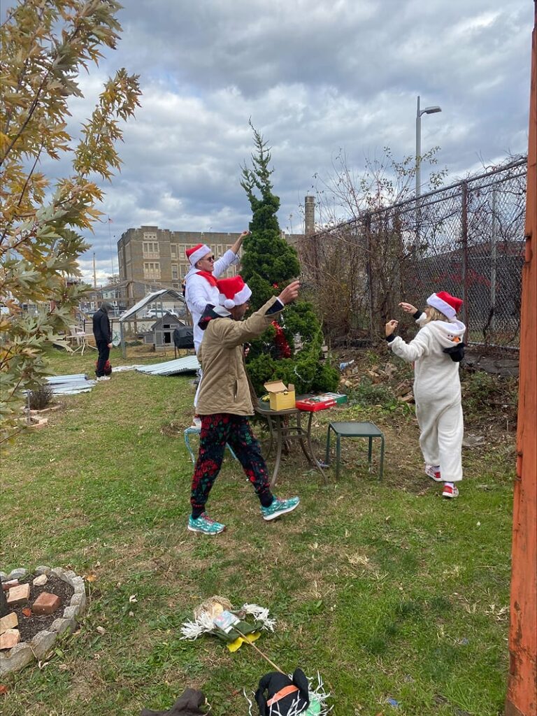 Team members stringing lights around a tree