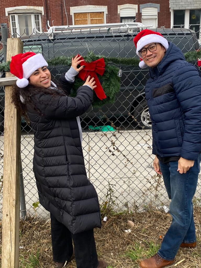 Team members hanging a wreath along the fence