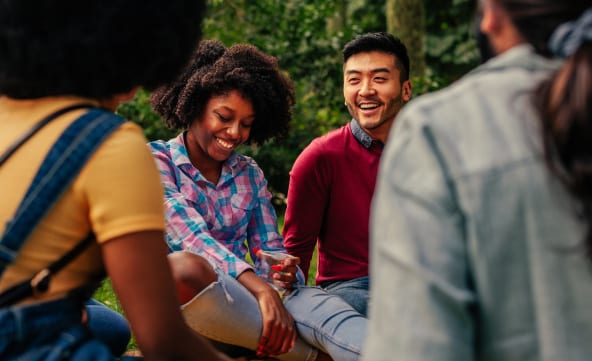 Group of friends sitting together outside in nature